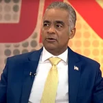 Hombre en traje con corbata amarilla. Tierras raras RD: Reservas netas listas en 2026