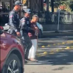 Agentes policiales auxilian a adulta mayor al cruzar avenida en Santiago